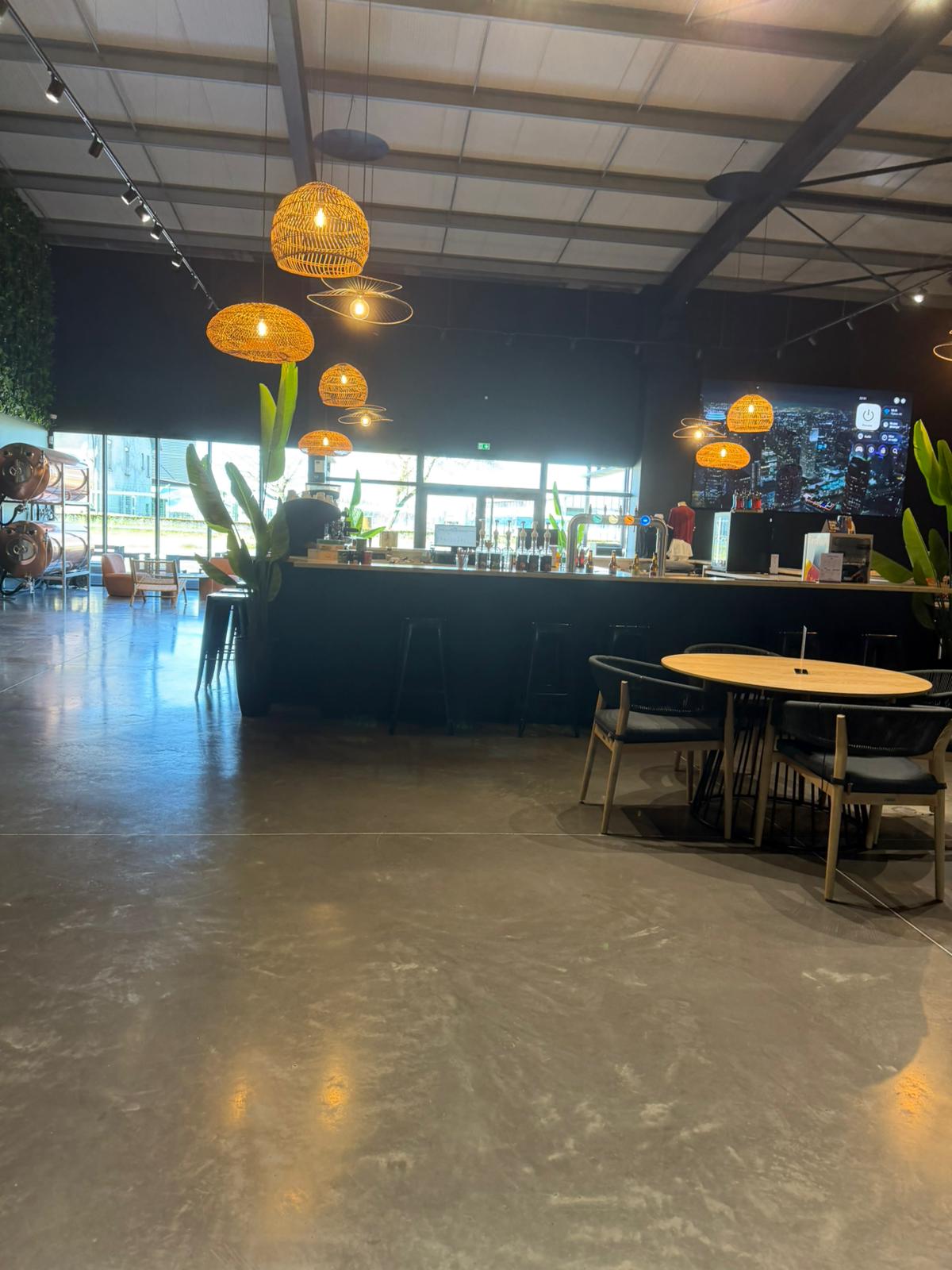 Padel Ground Tarbes — bar area with rattan pendant lighting