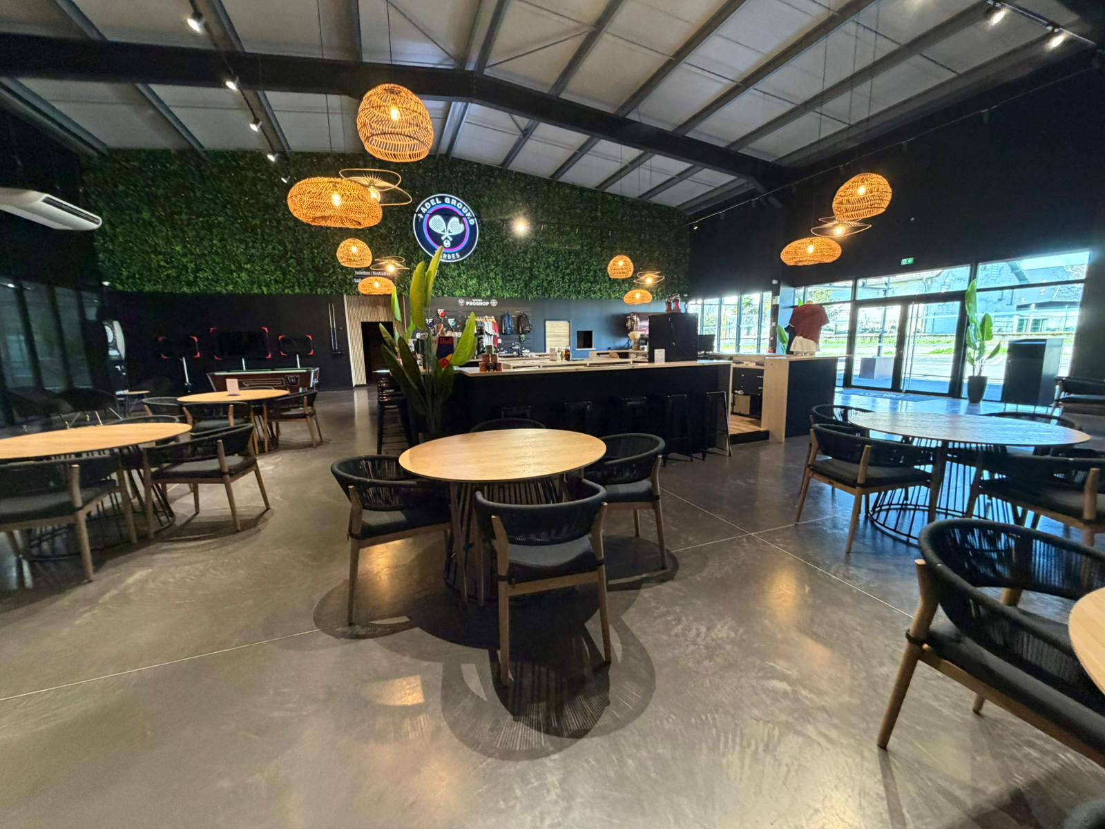Padel Ground Tarbes — full social area with green wall